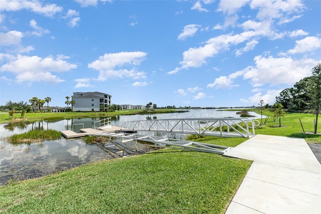 dock area with a lawn and a water view