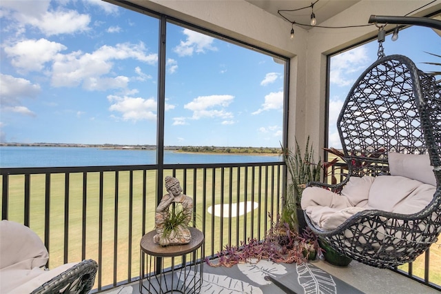sunroom featuring a water view