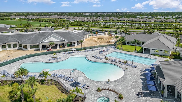 community pool featuring fence, golf course view, and a residential view