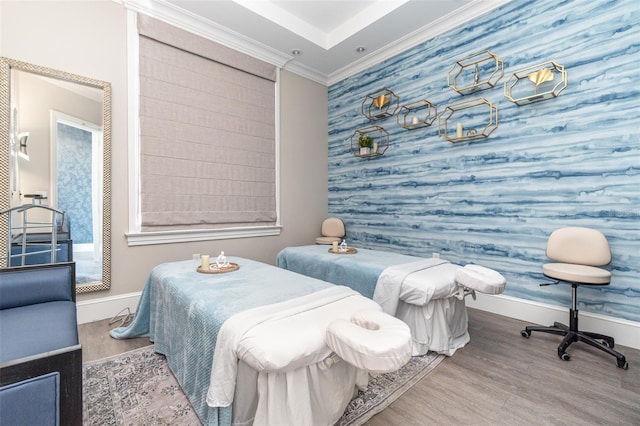 bedroom featuring baseboards, crown molding, and wood finished floors