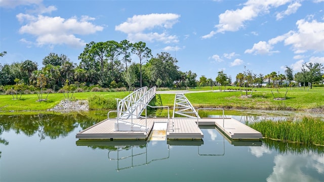view of dock featuring a lawn and a water view