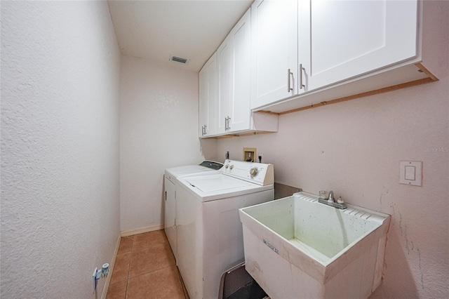 2751 S Cranberry Blvd, North Port, FL 34286 - laundry area featuring cabinet space, washer and dryer, light tile patterned floors, and baseboards