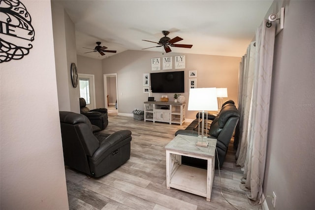 living room featuring a ceiling fan, vaulted ceiling, wood finished floors, and baseboards