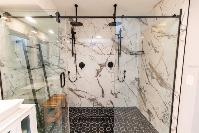 full bathroom with a marble finish shower and vanity