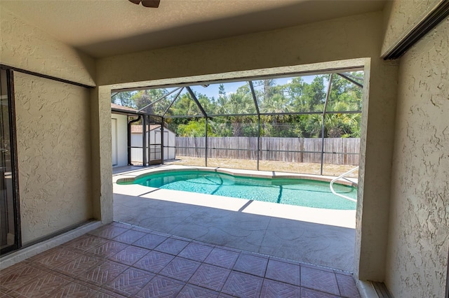 view of swimming pool with an outdoor structure, a fenced backyard, a shed, and a patio area