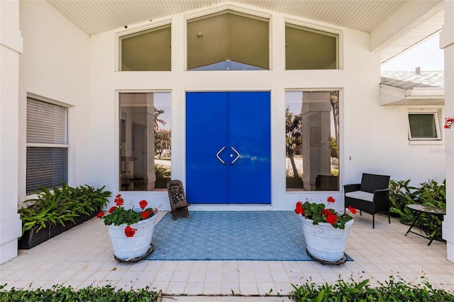 doorway to property featuring stucco siding