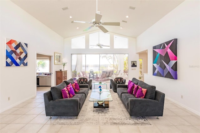 living area with light tile patterned floors, ceiling fan, high vaulted ceiling, and baseboards