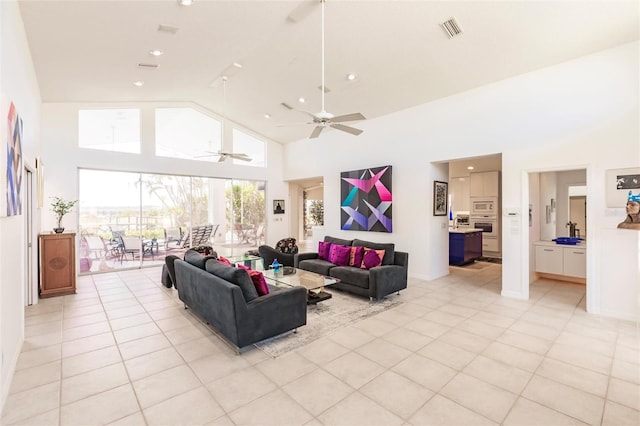 living area with recessed lighting, light tile patterned flooring, high vaulted ceiling, ceiling fan, and visible vents