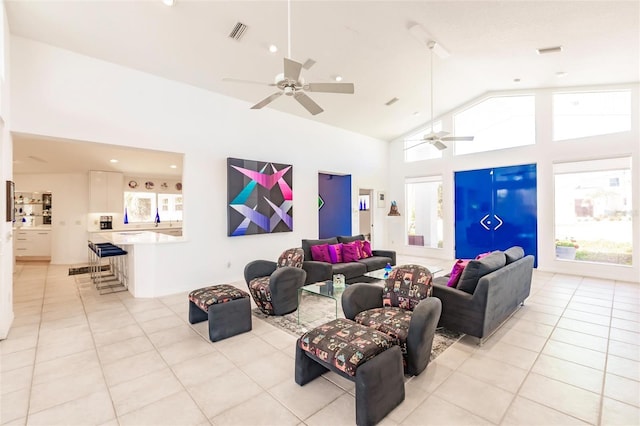 living area featuring visible vents, light tile patterned floors, a ceiling fan, and plenty of natural light