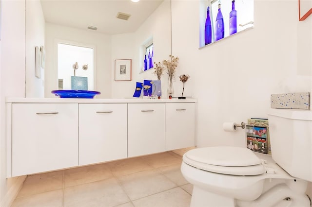 bathroom featuring vanity, visible vents, toilet, and tile patterned flooring