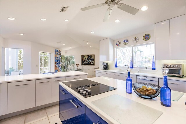 kitchen with black electric cooktop, light countertops, white cabinets, and a toaster