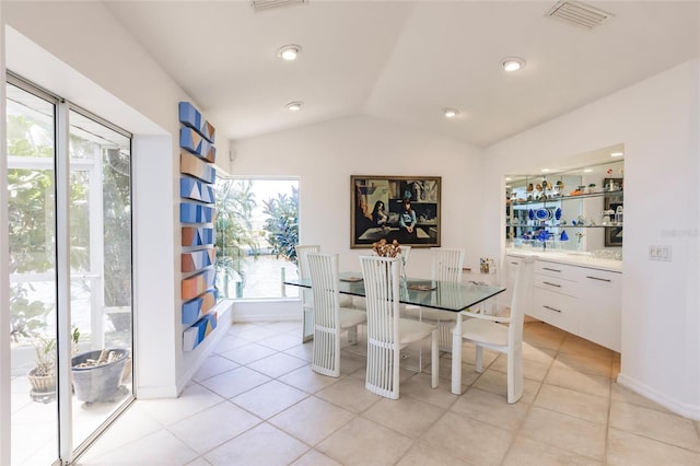 dining area with baseboards, visible vents, light tile patterned floors, and lofted ceiling
