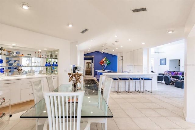 dining area featuring ceiling fan, lofted ceiling, and visible vents