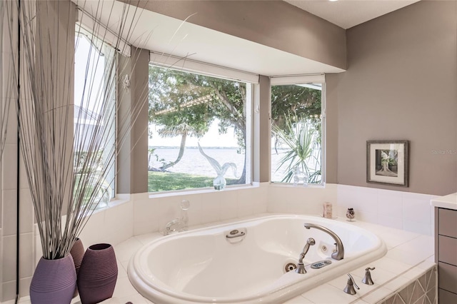 full bath with a healthy amount of sunlight, a whirlpool tub, and a water view