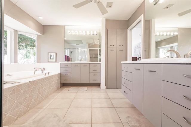 full bath featuring ceiling fan, a stall shower, two vanities, a bath, and tile patterned floors