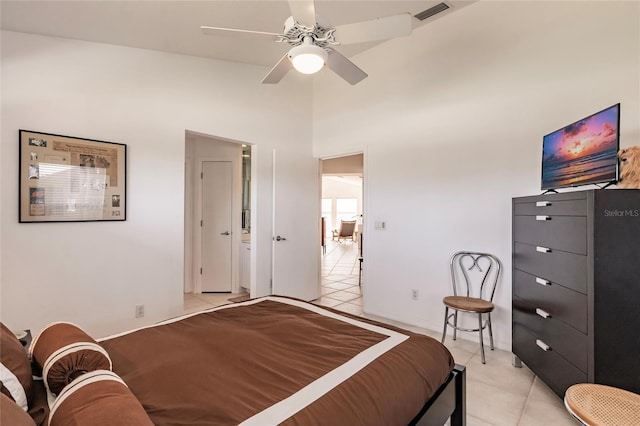 bedroom featuring light tile patterned floors, visible vents, a towering ceiling, and a ceiling fan