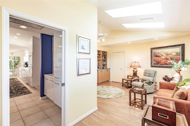hall with visible vents, lofted ceiling with skylight, light wood-style flooring, and recessed lighting