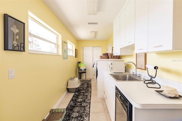 kitchen with white microwave, light countertops, a sink, white cabinetry, and visible vents