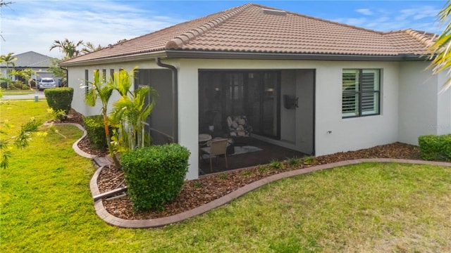 1745 Hyssop Loop, North Port, FL 34289 - back of property with a lawn, a tiled roof, stucco siding, and a sunroom