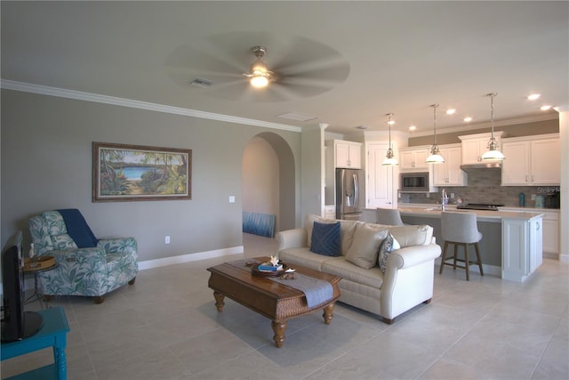 1745 Hyssop Loop, North Port, FL 34289 - living room with arched walkways, crown molding, light tile patterned floors, recessed lighting, and ceiling fan