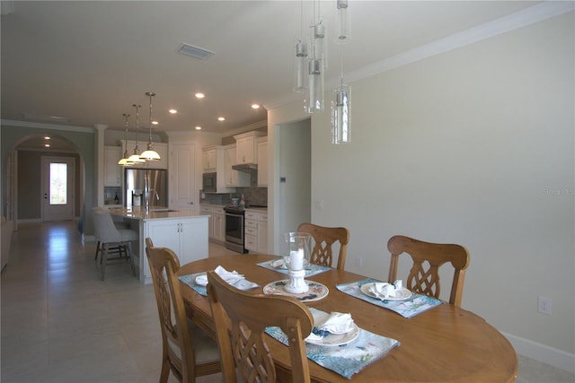 1745 Hyssop Loop, North Port, FL 34289 - dining area featuring ornamental molding, arched walkways, and recessed lighting