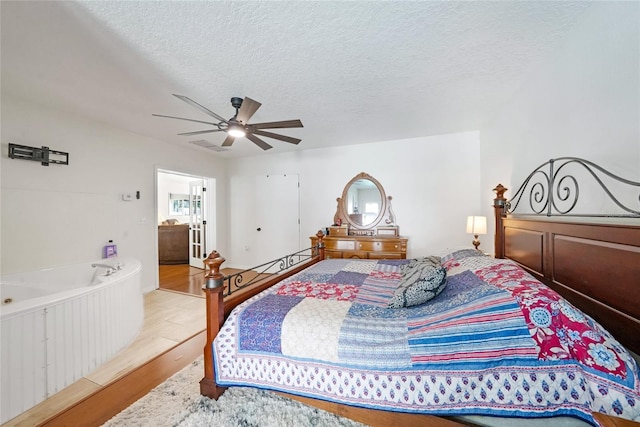 bedroom featuring wood finished floors, a ceiling fan, and a textured ceiling