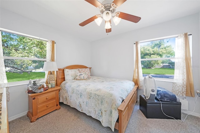 bedroom featuring a ceiling fan, light carpet, and baseboards