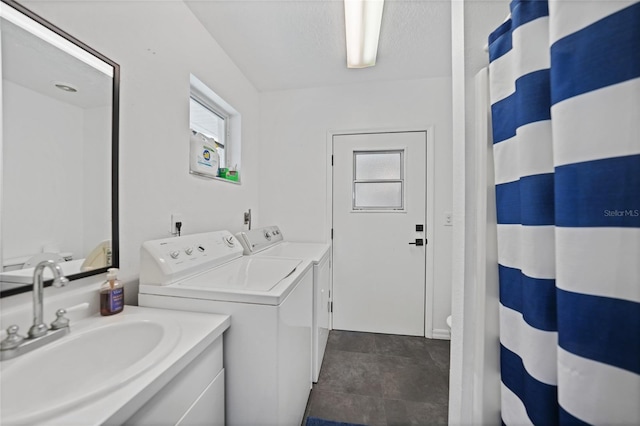 clothes washing area featuring a healthy amount of sunlight, separate washer and dryer, laundry area, and a sink
