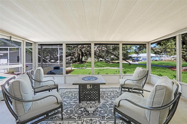 sunroom / solarium with an outdoor living space with a fire pit and a healthy amount of sunlight