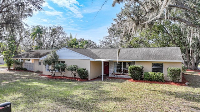 ranch-style home featuring stucco siding and a front yard