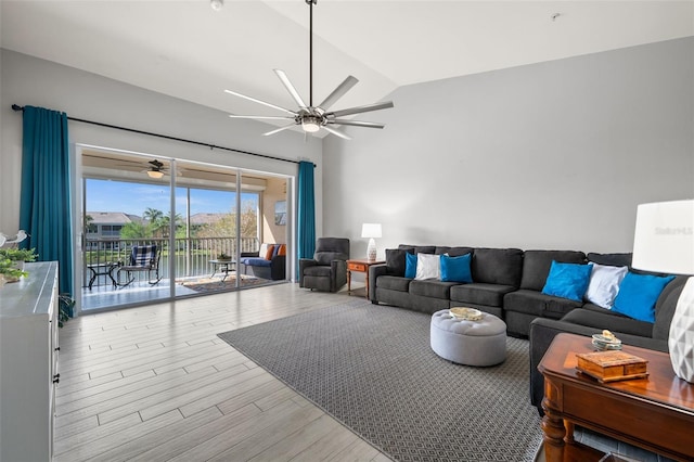 living area with wood finished floors, a ceiling fan, and vaulted ceiling