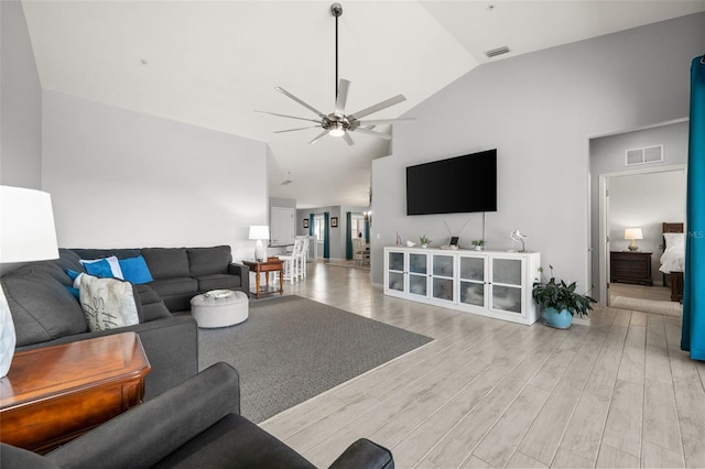 living area featuring a ceiling fan, visible vents, high vaulted ceiling, and wood finished floors