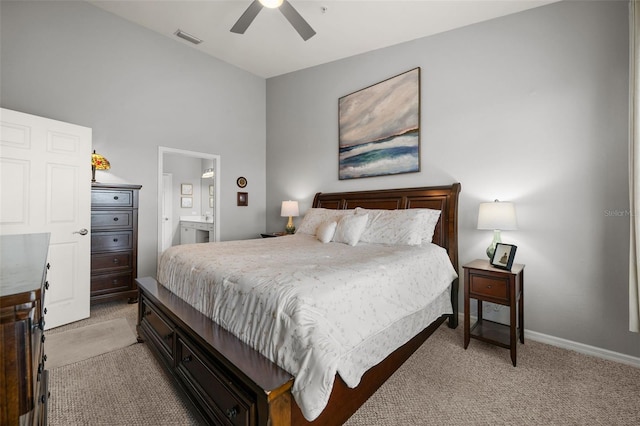 bedroom with visible vents, ensuite bathroom, a ceiling fan, and light colored carpet