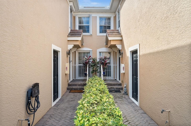 doorway to property featuring stucco siding