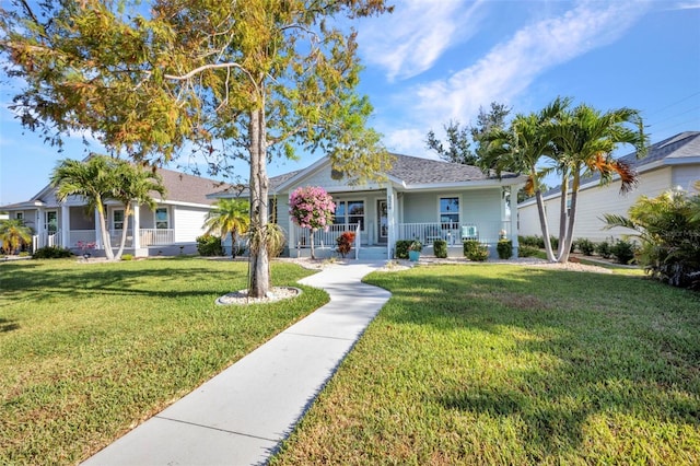 view of front of home featuring a front yard, a porch, and a shingled roof