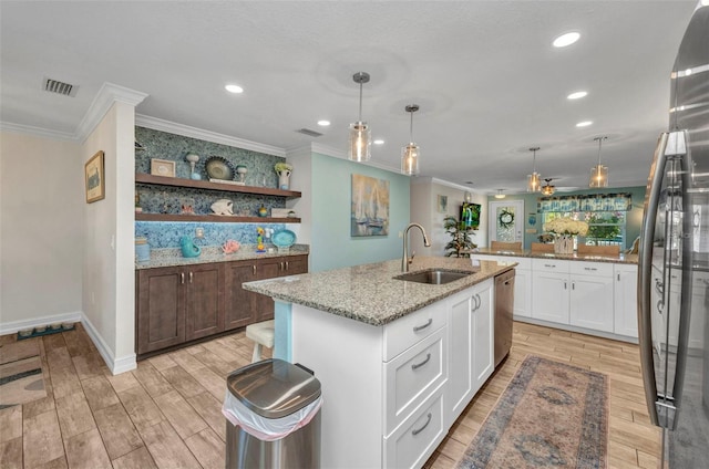 kitchen with crown molding, wood finish floors, a sink, and stainless steel appliances