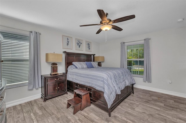 bedroom with ceiling fan, baseboards, and light wood-type flooring