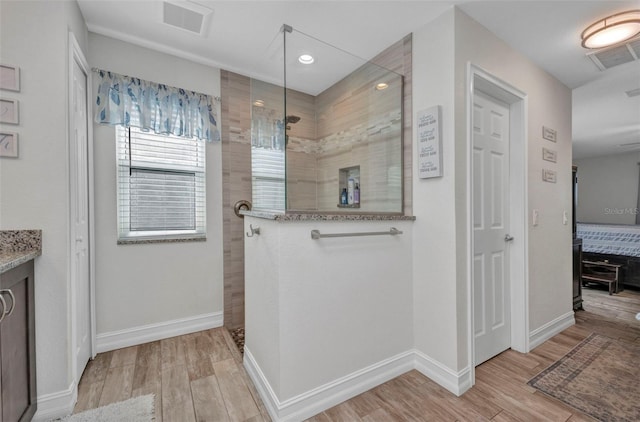 bathroom with walk in shower, wood finished floors, and baseboards