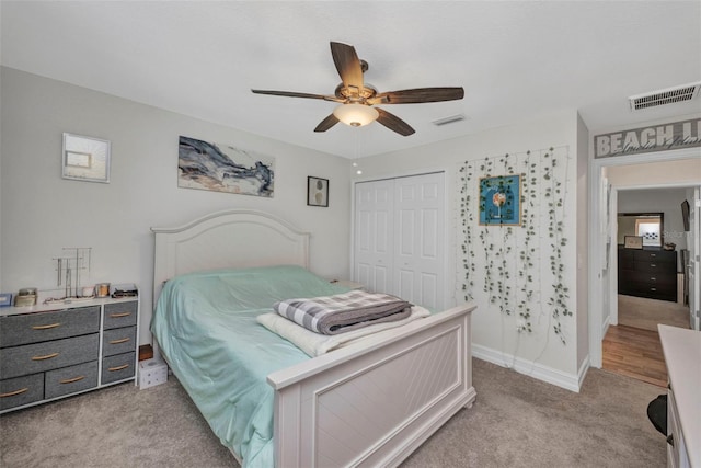 bedroom featuring light colored carpet, visible vents, ceiling fan, and a closet