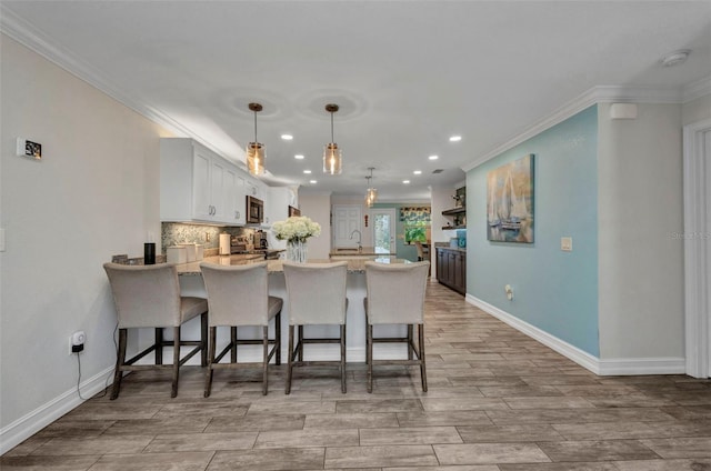 kitchen featuring recessed lighting, stainless steel appliances, a peninsula, and crown molding