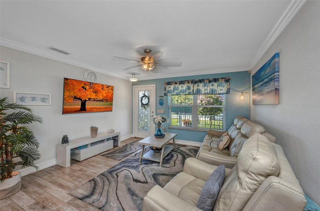 living area featuring baseboards, ornamental molding, ceiling fan, and wood finished floors