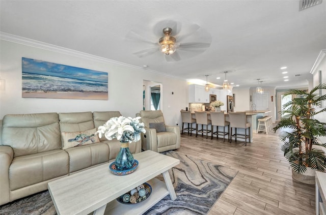 living room featuring recessed lighting, ceiling fan, crown molding, visible vents, and light wood-style flooring