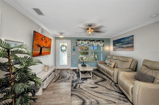 living area with visible vents, baseboards, ornamental molding, wood finished floors, and a ceiling fan