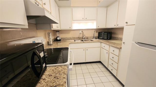 21300 Brinson Ave Unit 201, Port Charlotte, FL 33952 - kitchen with white cabinets, a sink, freestanding refrigerator, light tile patterned floors, and under cabinet range hood