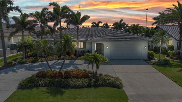 80 Hibiscus Dr, Punta Gorda, FL 33950 - view of front of property featuring an attached garage, driveway, a front lawn, a tiled roof, and stucco siding