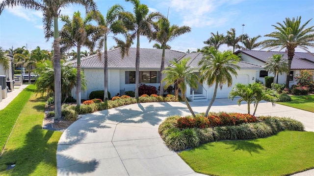 80 Hibiscus Dr, Punta Gorda, FL 33950 - view of front of house with concrete driveway, a garage, a front yard, and a tile roof