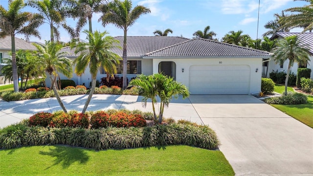 80 Hibiscus Dr, Punta Gorda, FL 33950 - view of front facade featuring a garage, concrete driveway, a front lawn, and a tiled roof