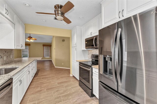 80 Hibiscus Dr, Punta Gorda, FL 33950 - kitchen featuring appliances with stainless steel finishes, a ceiling fan, a sink, white cabinets, and tasteful backsplash
