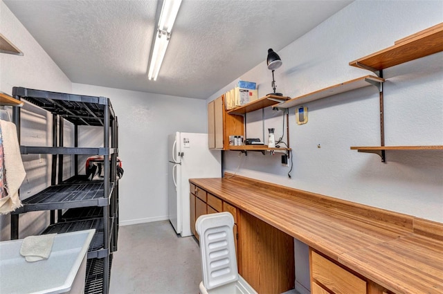 80 Hibiscus Dr, Punta Gorda, FL 33950 - kitchen with open shelves, freestanding refrigerator, concrete flooring, a textured ceiling, and baseboards