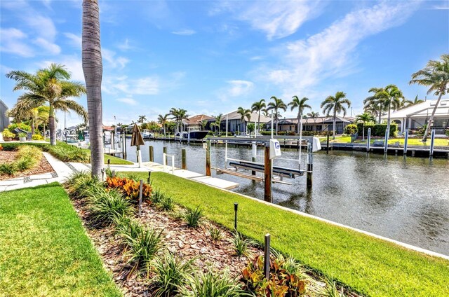 80 Hibiscus Dr, Punta Gorda, FL 33950 - dock area with boat lift, a water view, a lawn, and a residential view